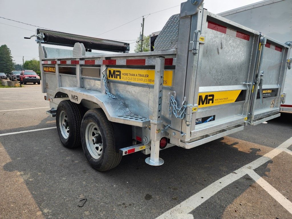 Une remorque à benne basculante est garée sur un parking à côté d'une remorque.