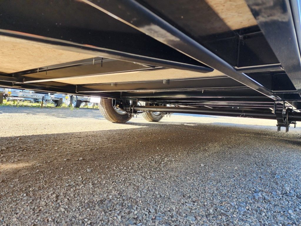 Le dessous d'une remorque est montré sur une route de gravier.