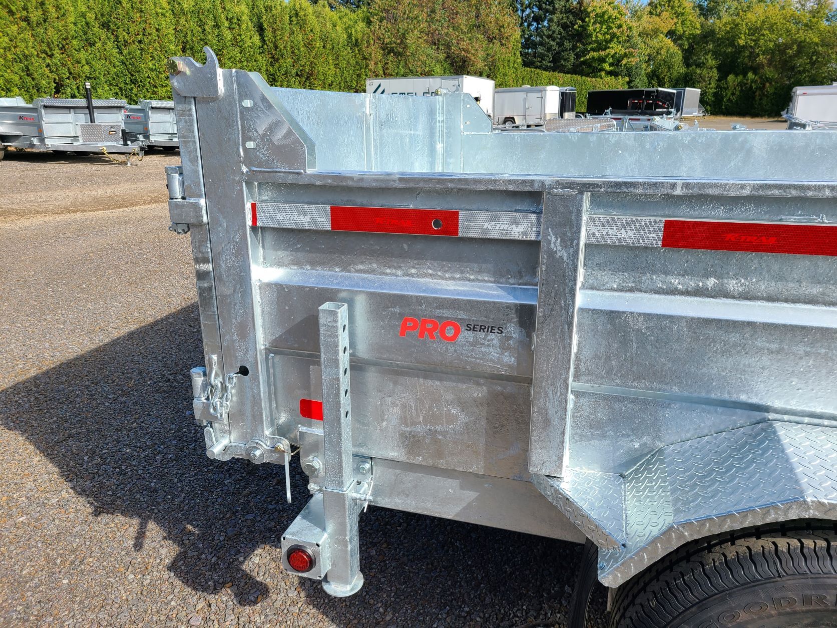 Une remorque à benne basculante est garée sur le bord de la route.