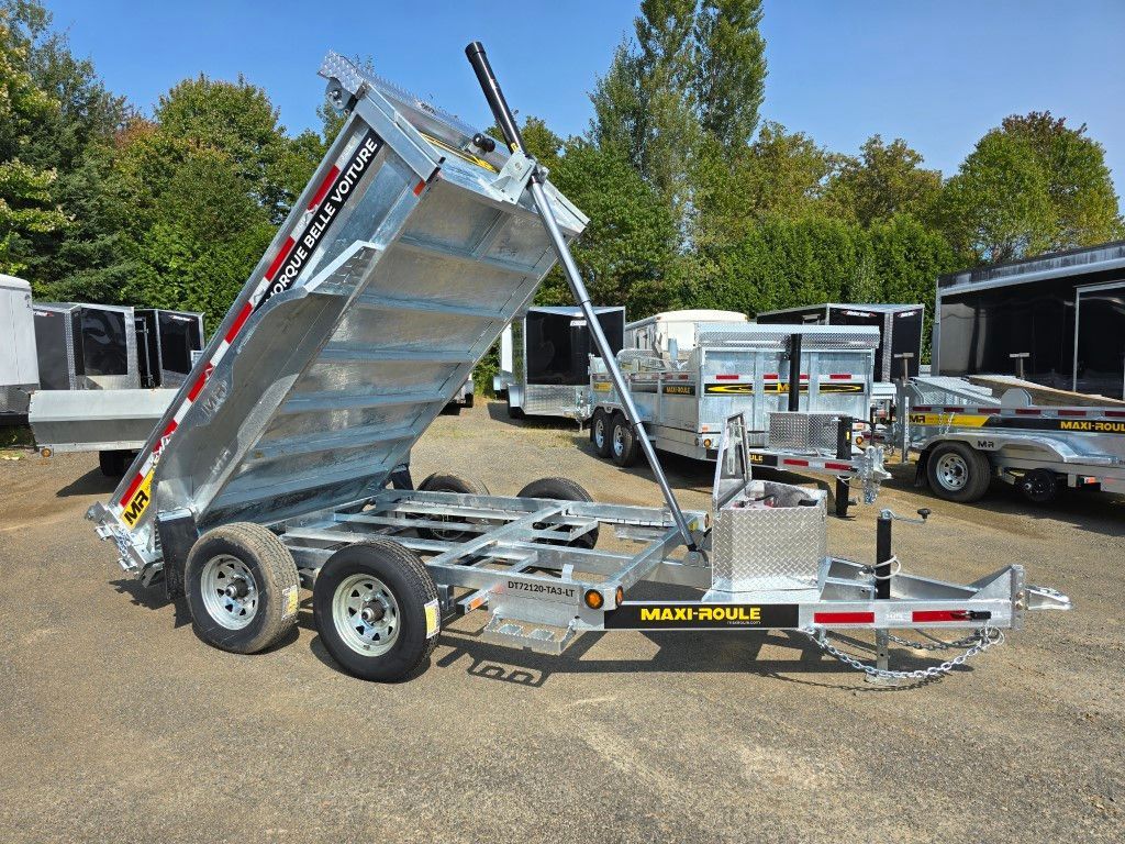 Une remorque à benne basculante est garée dans un parking.