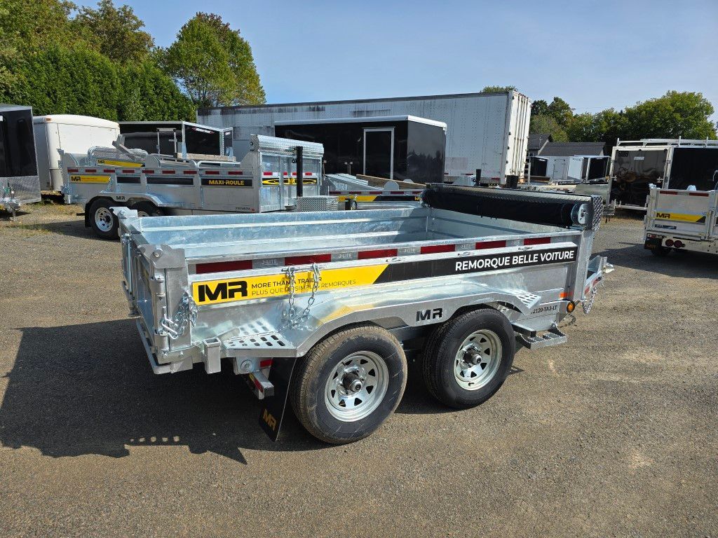 Une remorque est garée sur un parking à côté d'un bâtiment.