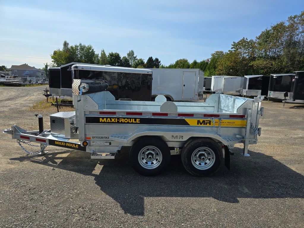 Une remorque à benne basculante est garée dans un parking.