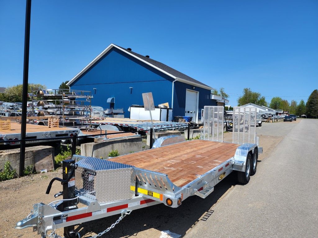 Une remorque est garée devant un bâtiment bleu.