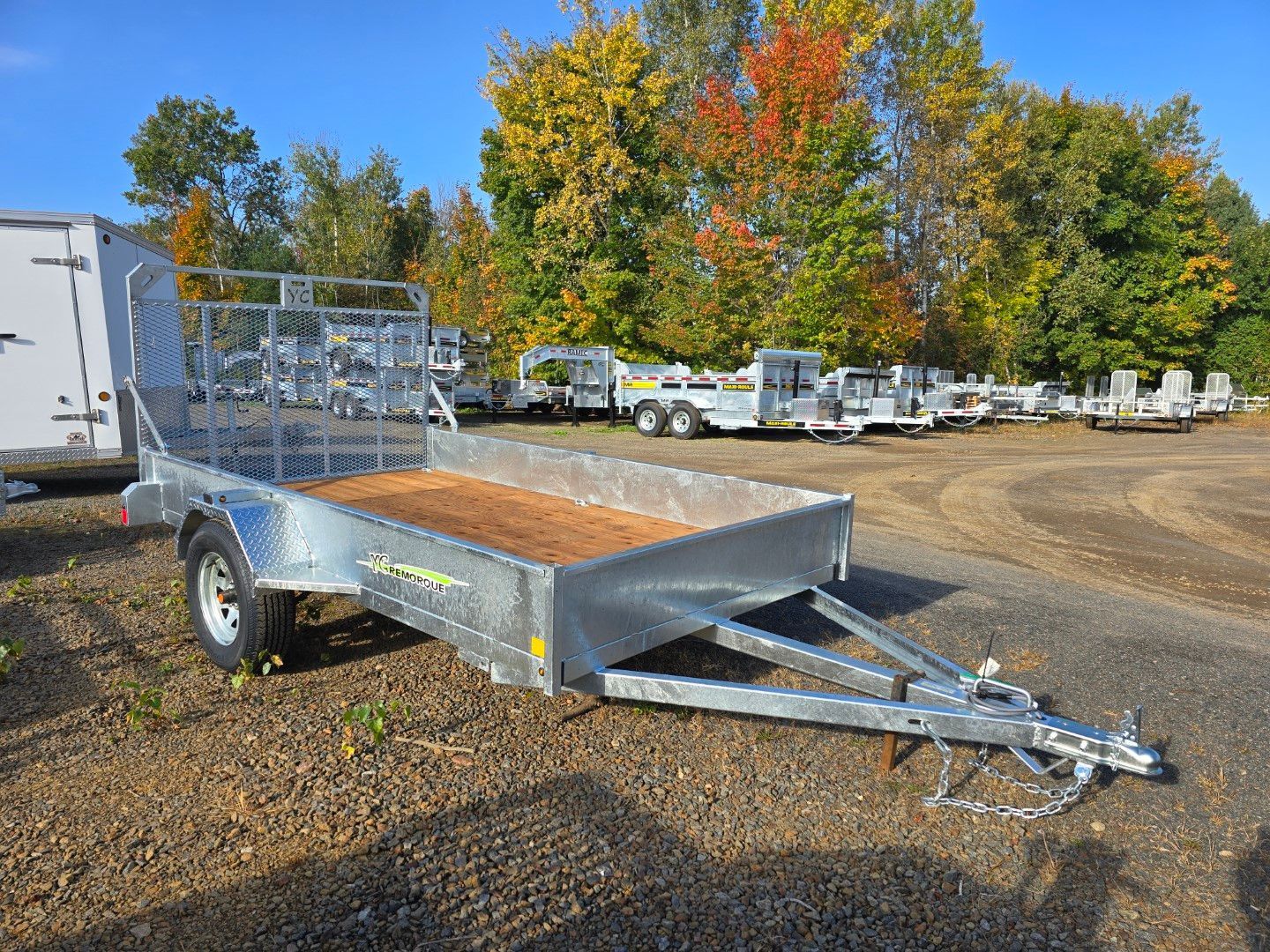 Une remorque est garée sur un terrain avec des arbres en arrière-plan.