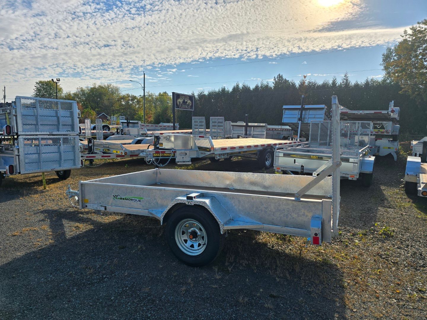 Une remorque est garée sur un terrain en gravier.