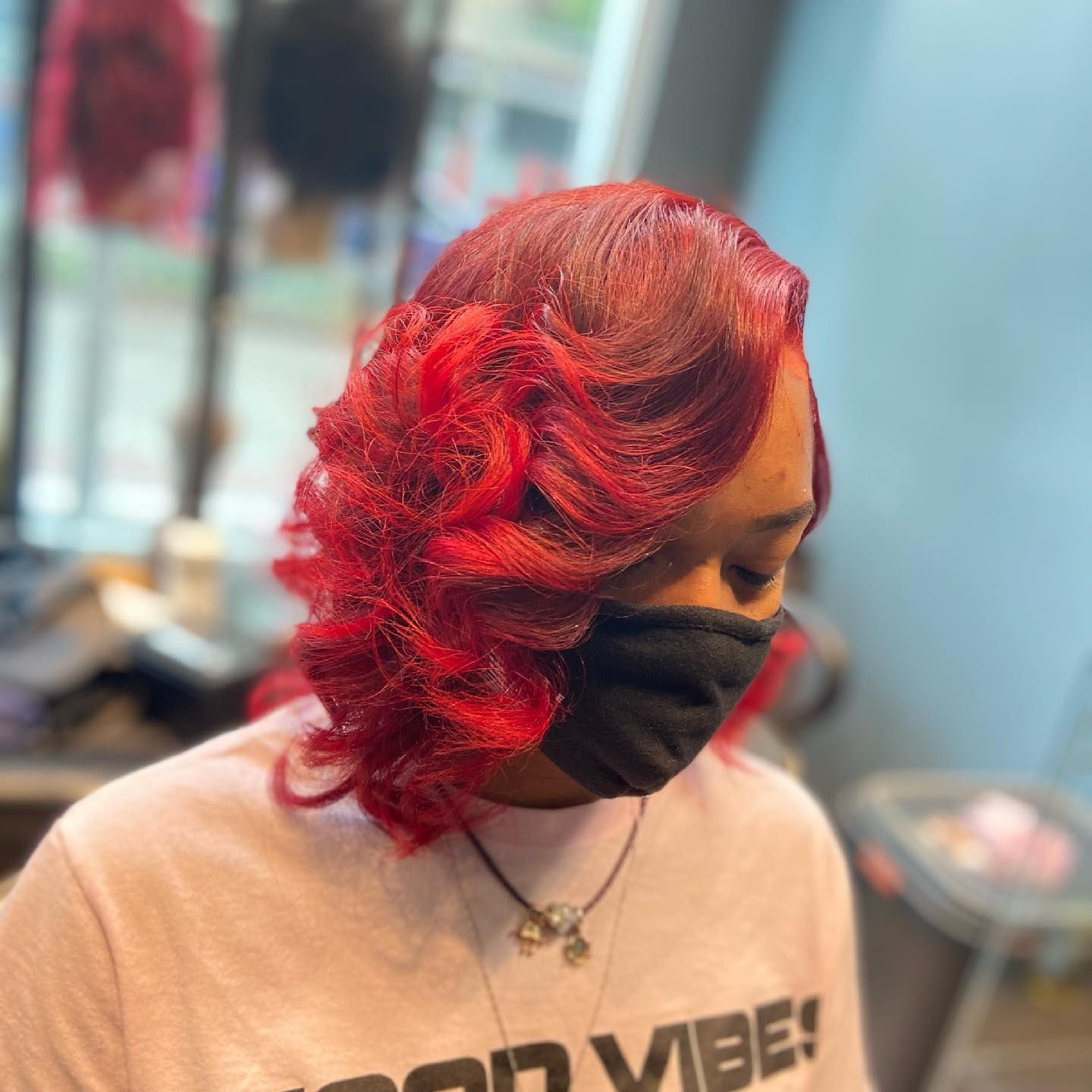 Woman with bright red hair and black face mask.