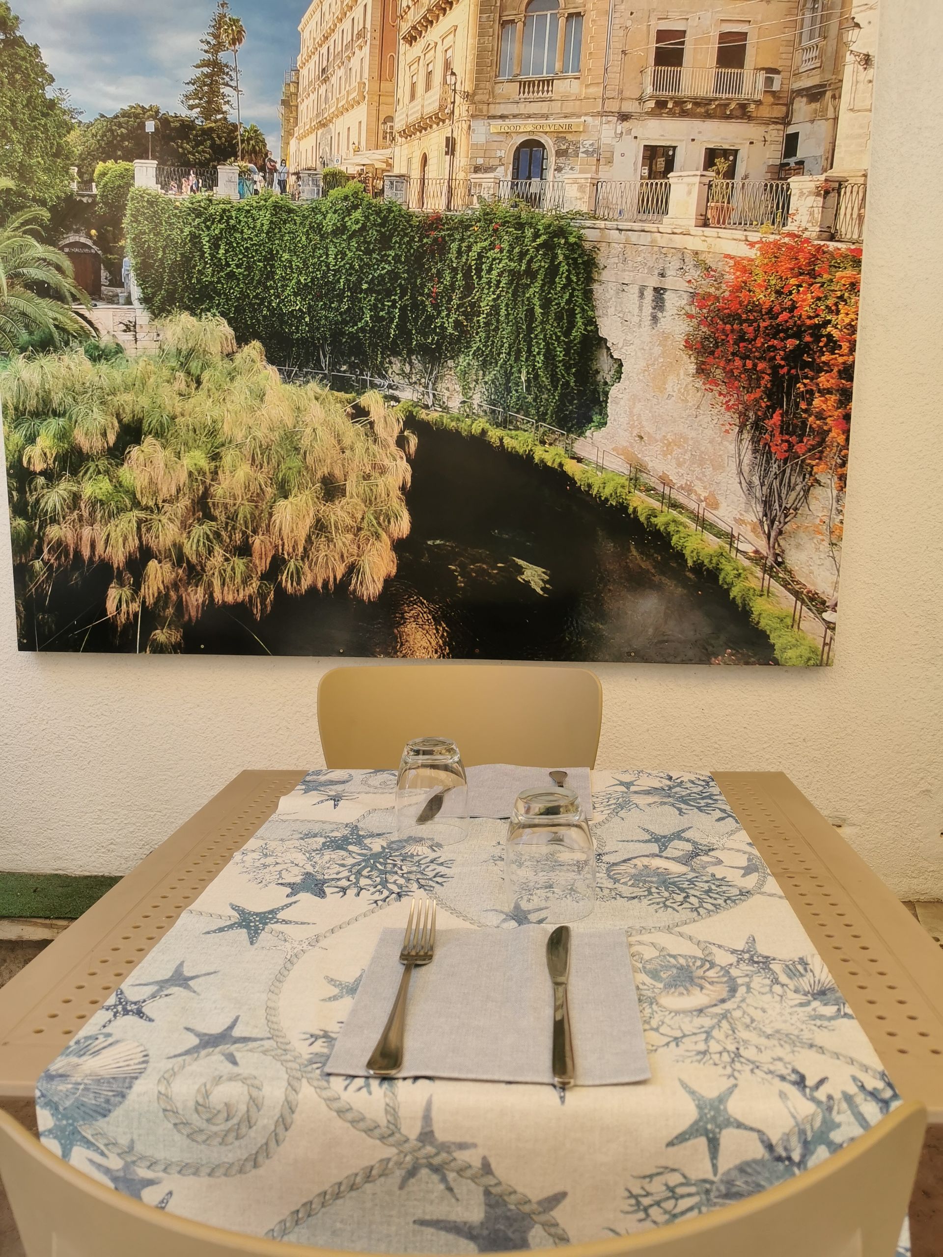 Un tavolo con l'immagine di un fiume sul muro dietro di esso