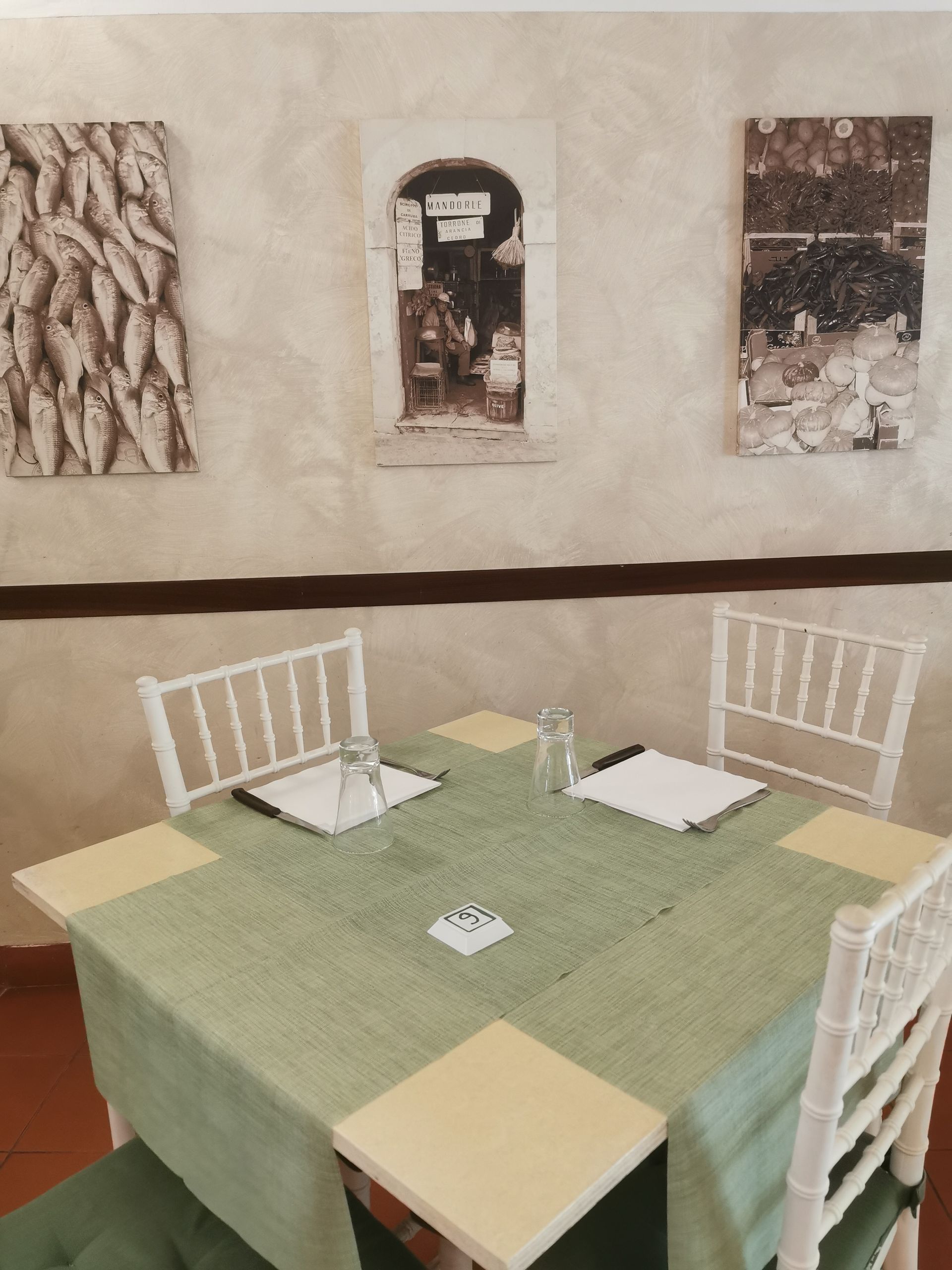 Un tavolo e delle sedie in una stanza con quadri sul muro