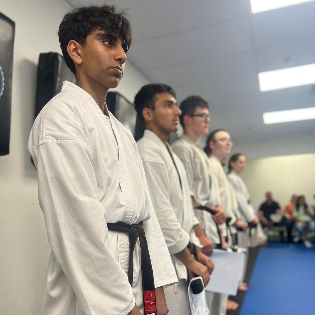 Four men in athletic gear, posing for a photo in a gym.