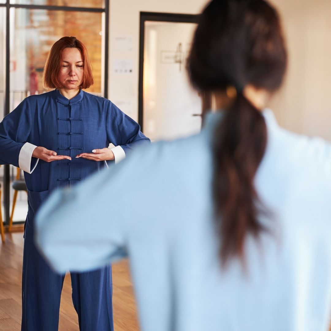 Two men grappling on a mat, one in blue, the other in black.