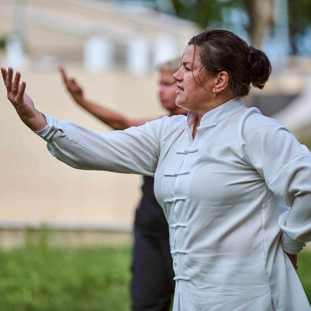 Two people practicing Brazilian Jiu-Jitsu on a mat; one in a black gi, one in a white gi, grappling.