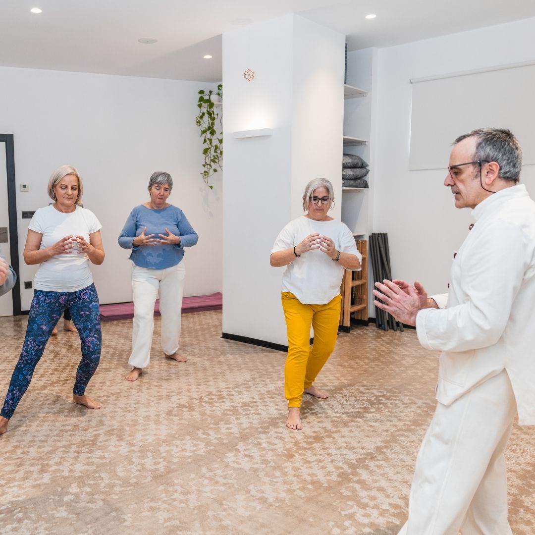 Five people in jiu-jitsu gear pose together in a gym.  Smiling,  some have arms around each other. Machado logo visible.