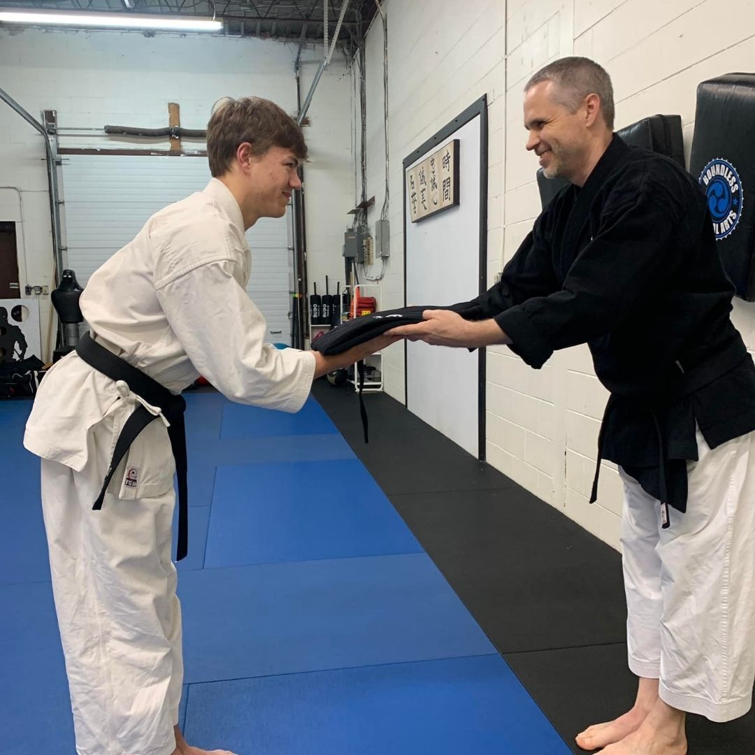 Two people practicing Brazilian Jiu-Jitsu on a mat. One is on top, applying a hold.