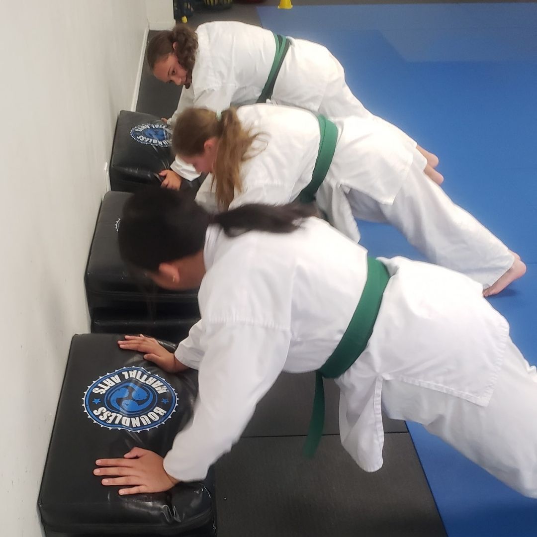 Two men grappling on a mat, one in blue, the other in black.