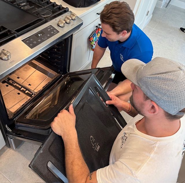A man is opening an oven door in a kitchen.