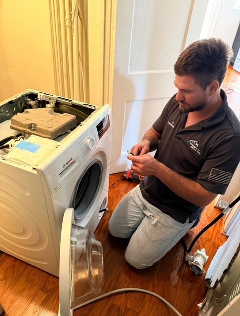 A man is taking a filter out of a washing machine