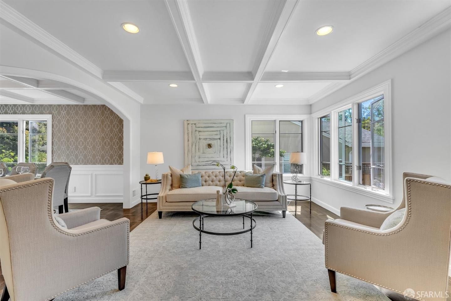 A living room with a couch , chairs , and a coffee table.