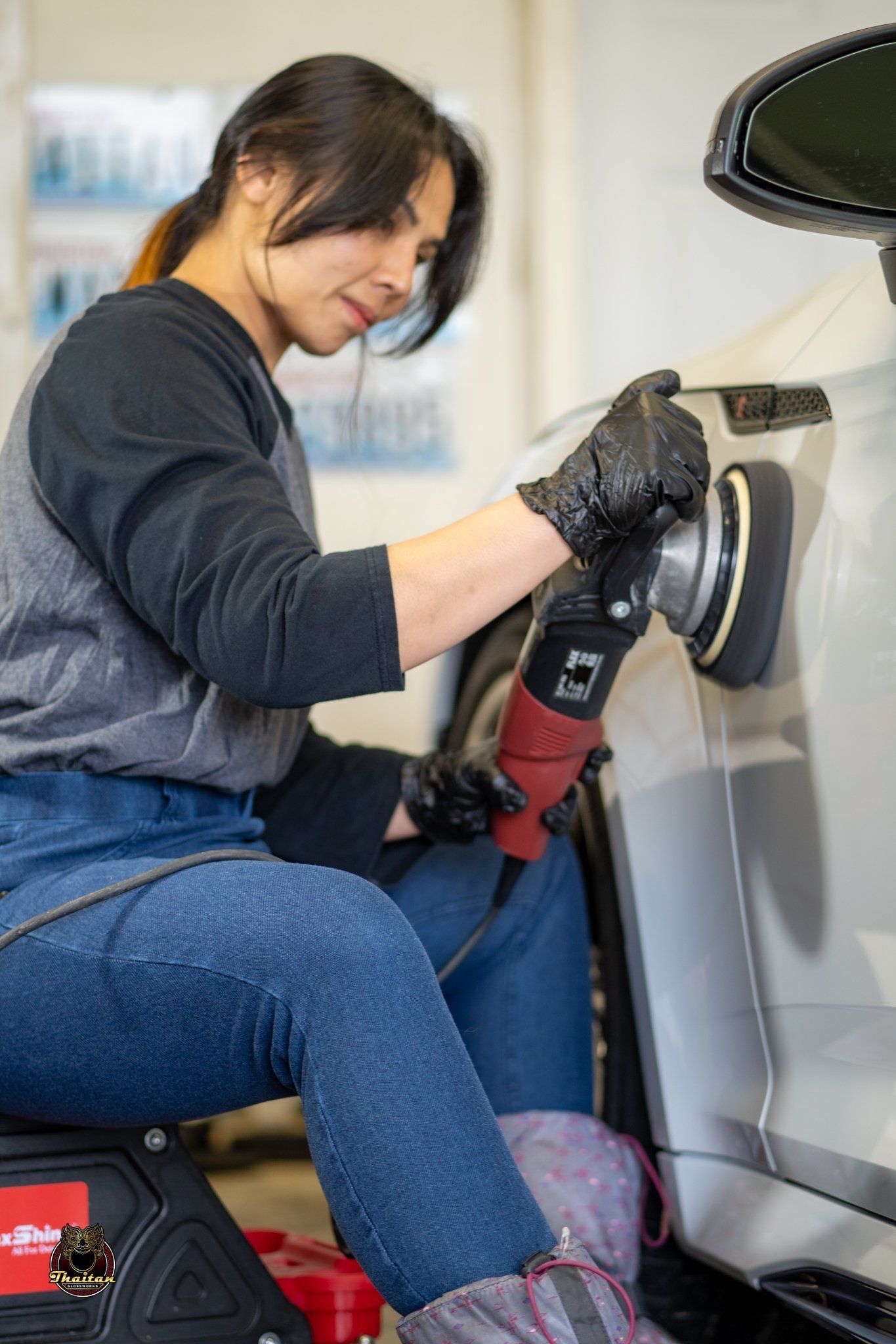 A man is polishing a car with a polisher.