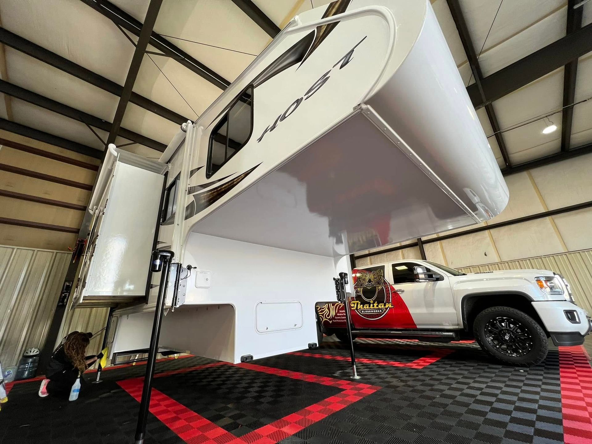 A truck with a trailer attached to it is parked in a garage.