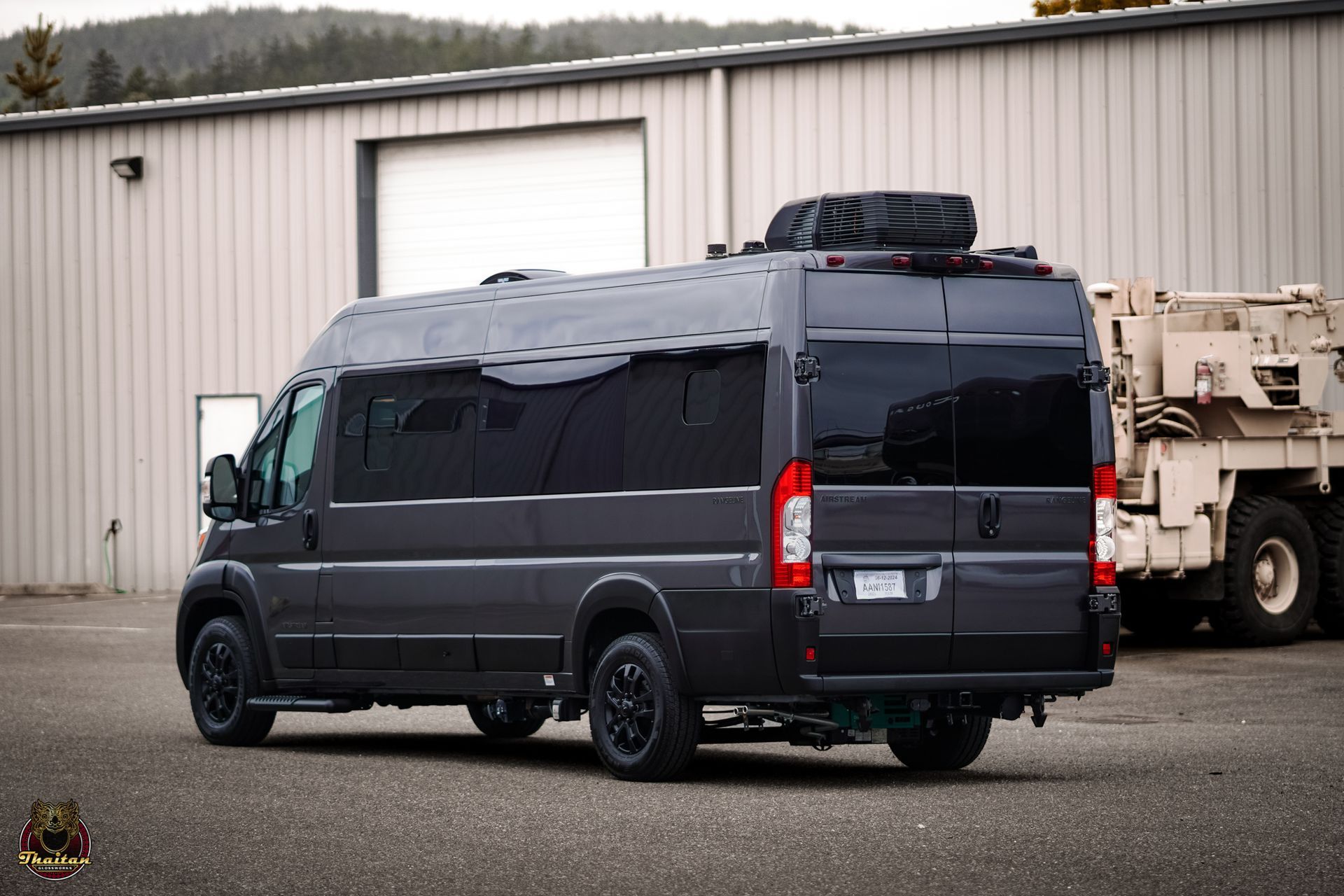 A gray van is parked in front of a building.