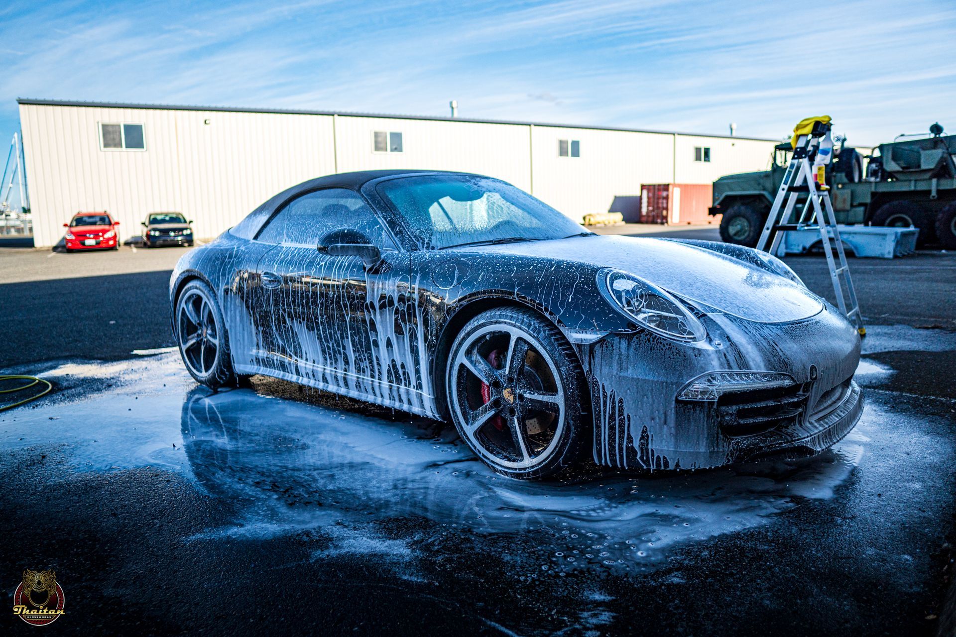 A car is covered in foam in a parking lot.