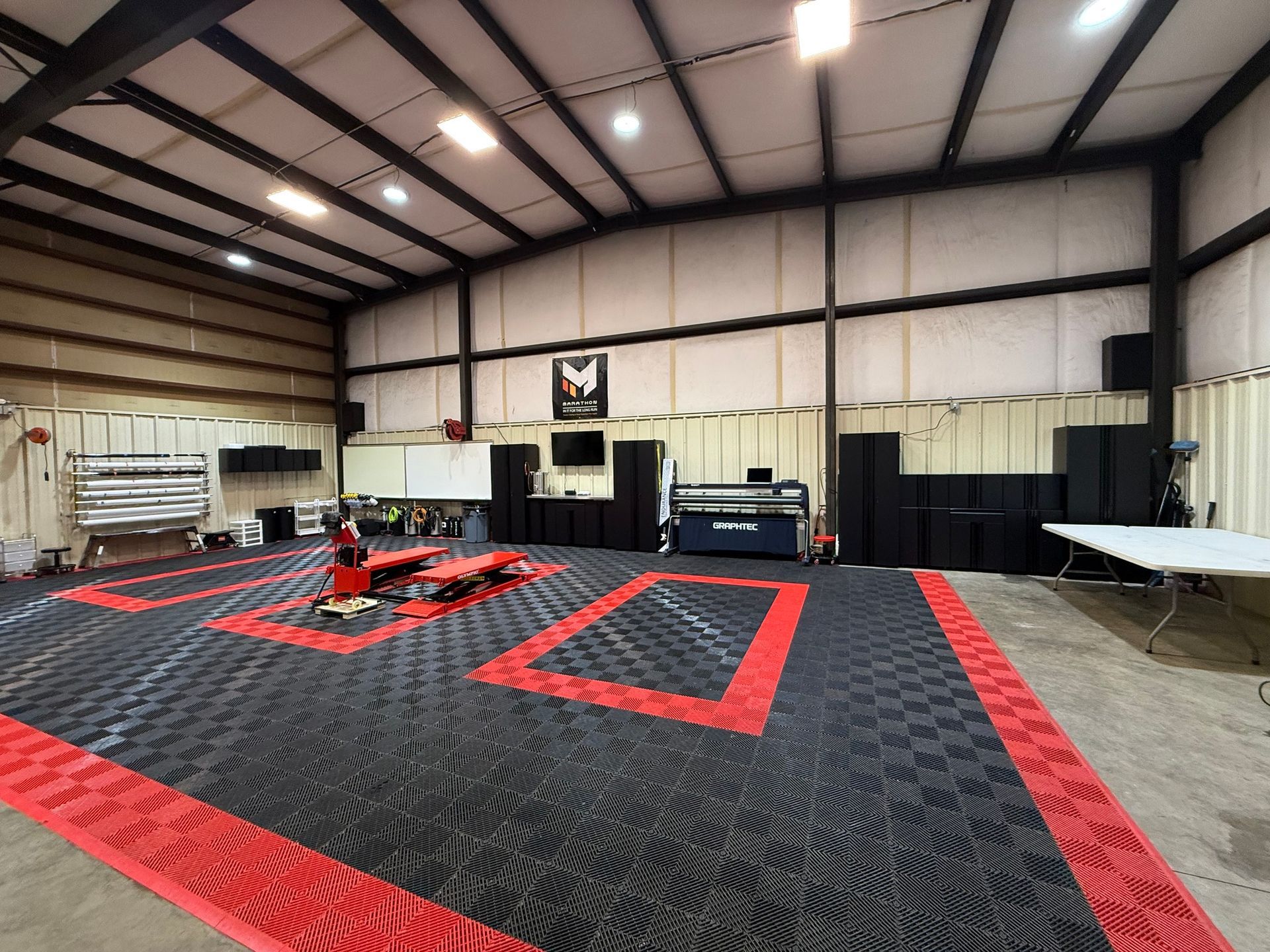 A large room with a red and black floor and a table.