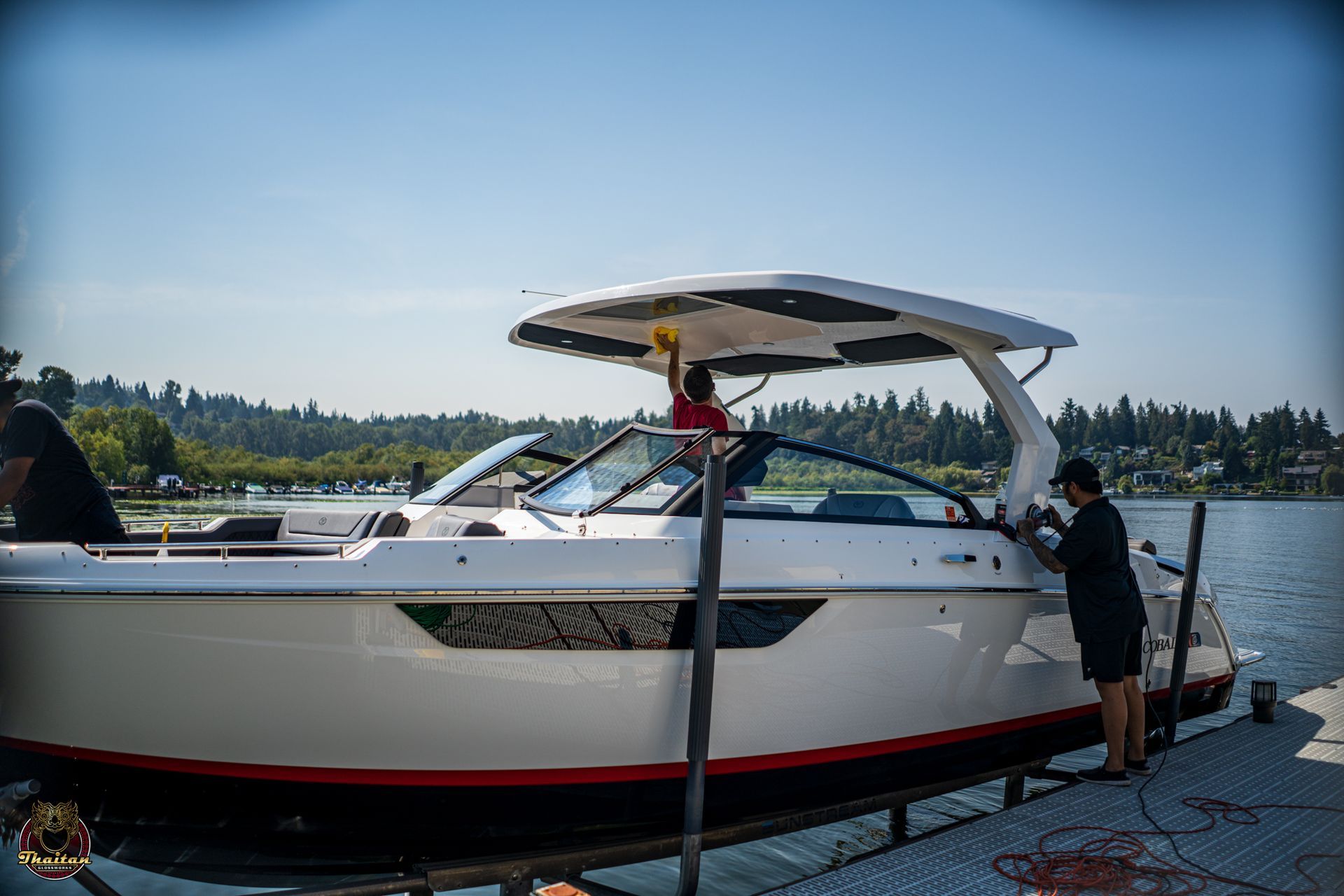 A man is cleaning a yamaha outboard motor with a cloth.