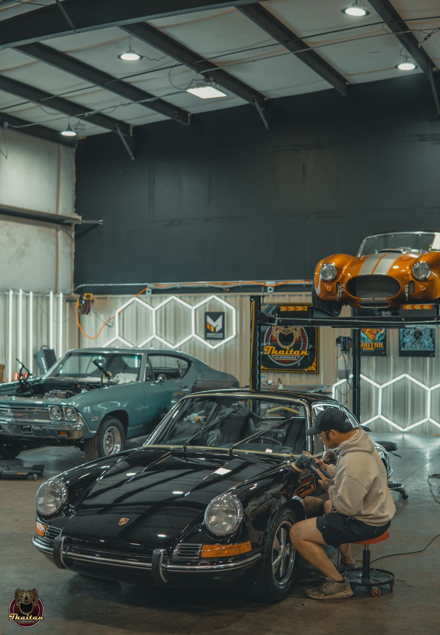 A woman is washing a car in a parking lot