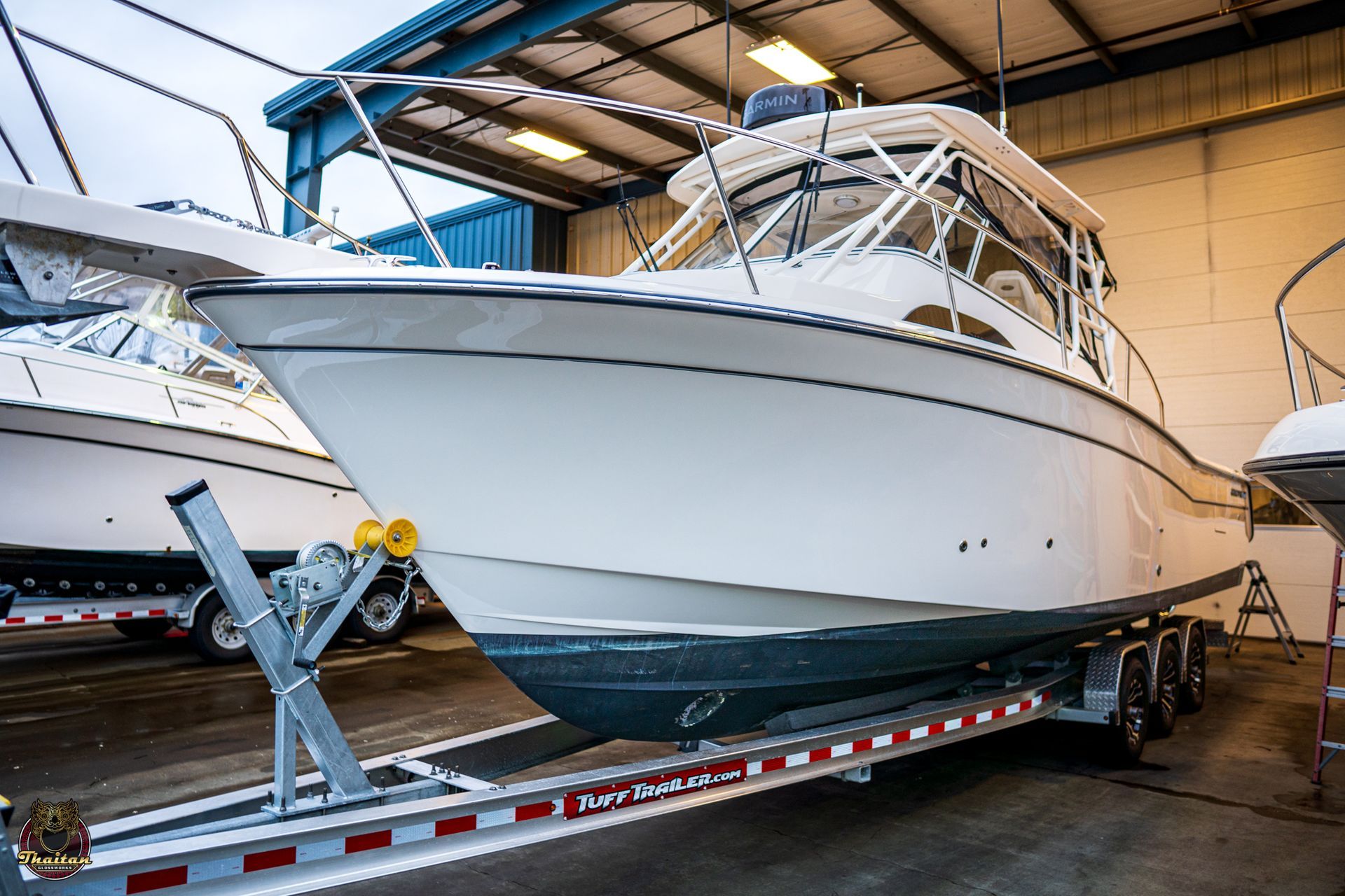 A man is polishing the side of a boat with a machine.