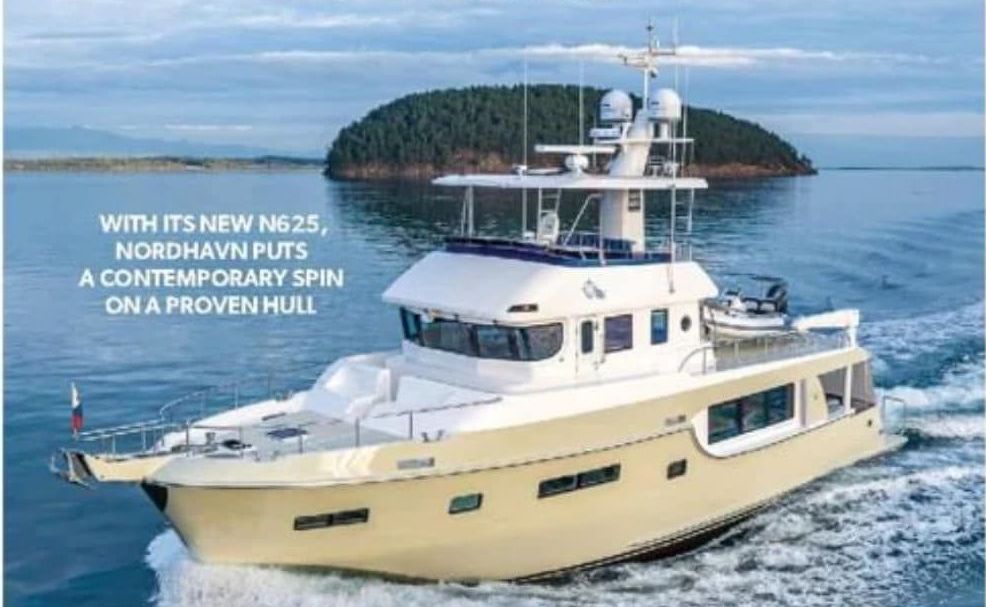 A white boat is on a trailer in a warehouse.