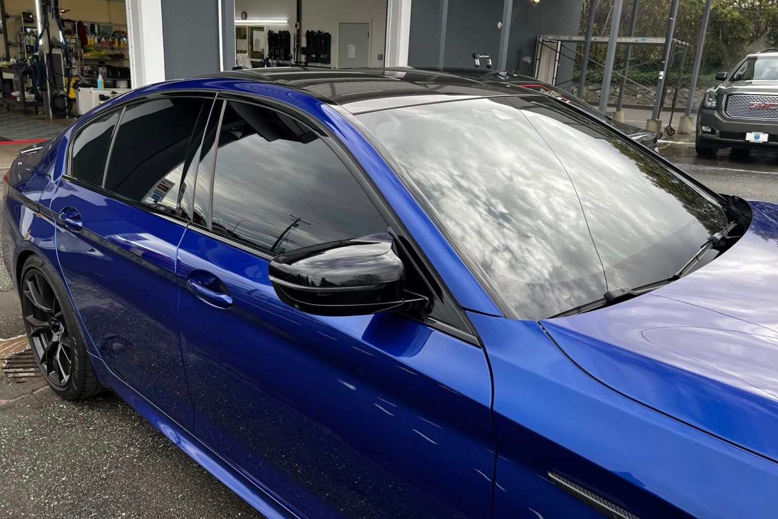 Blue sedan with tinted windows parked outside a building.