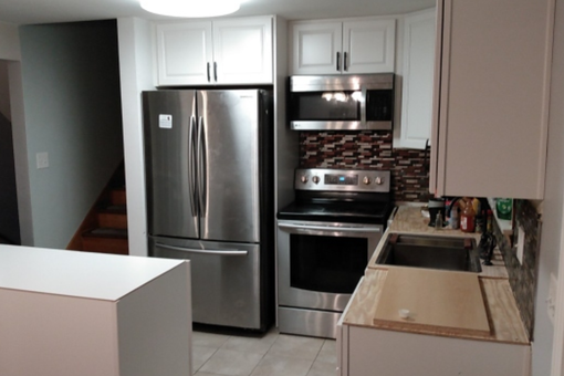 A kitchen with stainless steel appliances and white cabinets