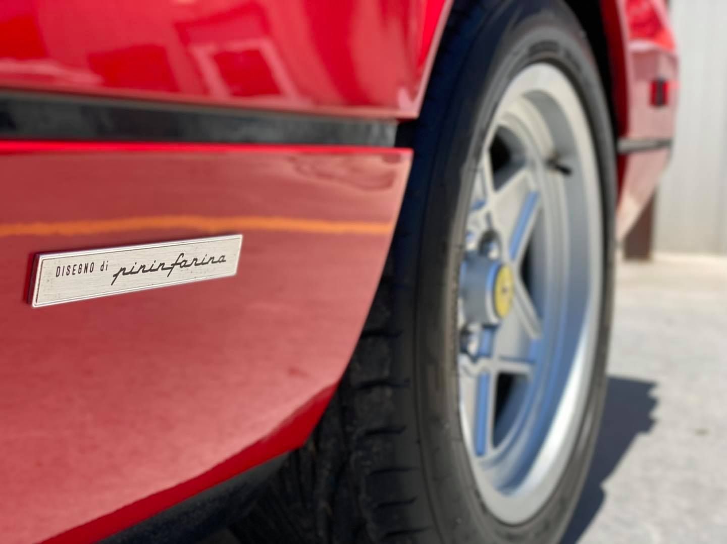 A close up of a red car with a ferrari logo on the side