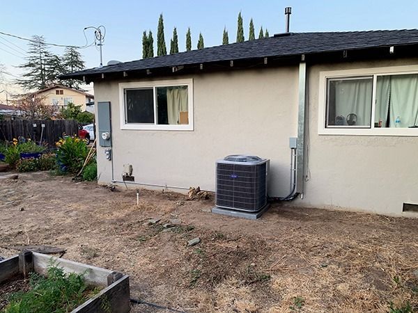 A house with a window and an air conditioner on the side of it.