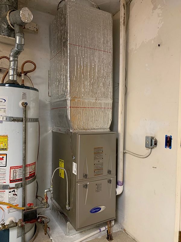 A water heater and a furnace are sitting next to each other in a room.