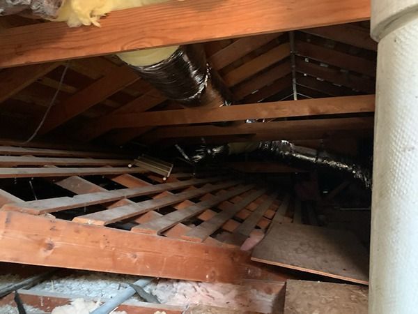 An attic with a lot of wooden beams and pipes