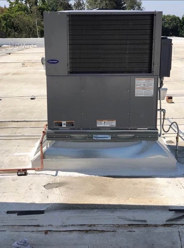 A carrier air conditioning is sitting on top of a roof.
