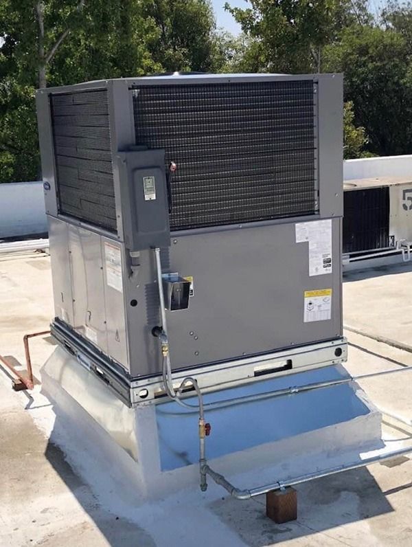 A Carrier air conditioning is sitting on top of a roof.