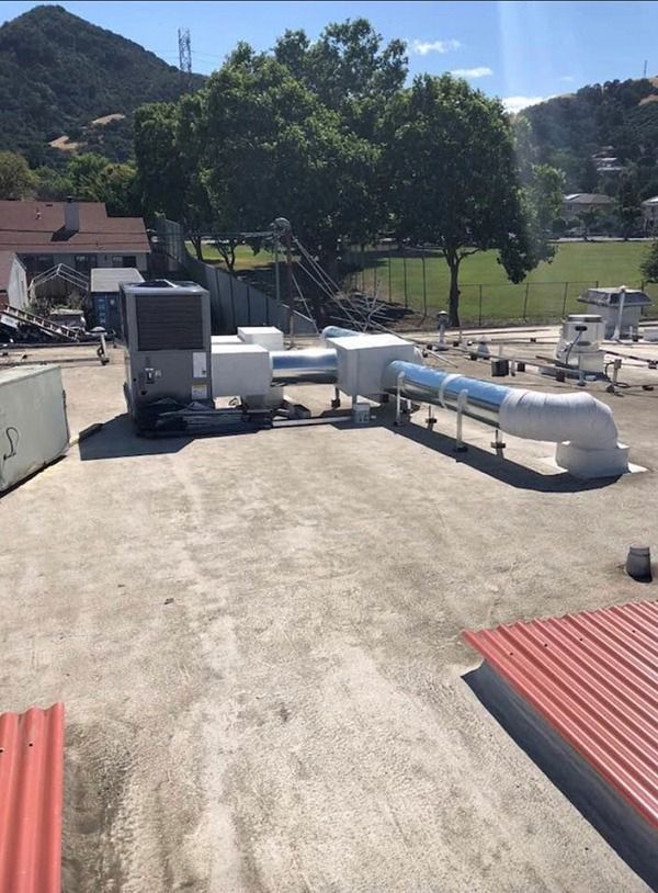 A rooftop with a lot of pipes coming out of it