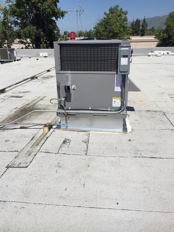 A Carrier air conditioning is sitting on top of a roof.