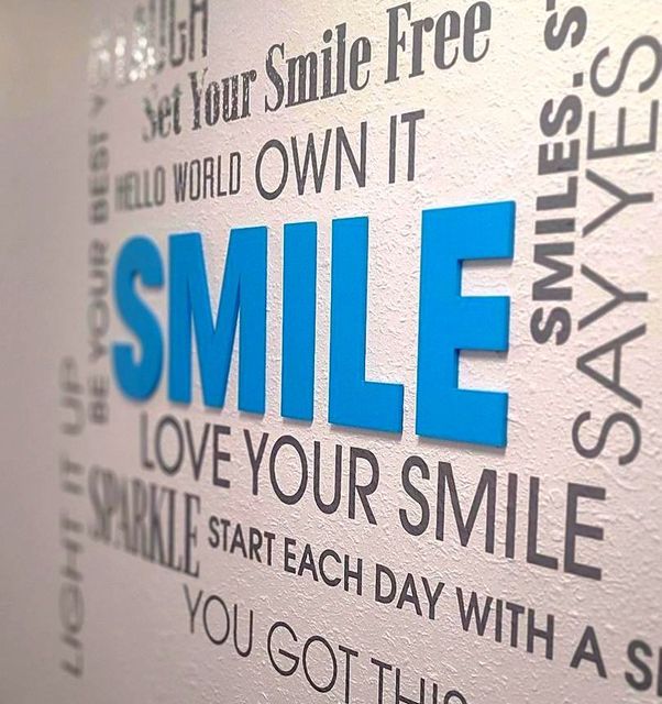 A sign on a wall that says set your smile free