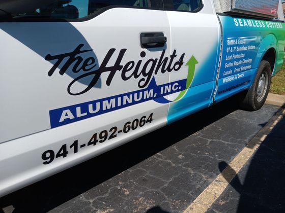 A white and blue truck with the heights aluminum inc. written on the side