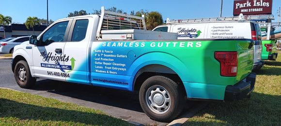 A seamless gutters truck is parked in a parking lot.