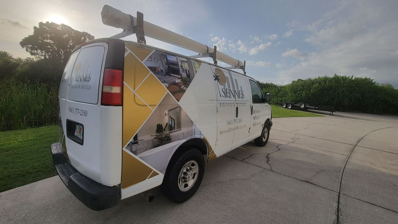 A white and gold van is parked on the side of the road.