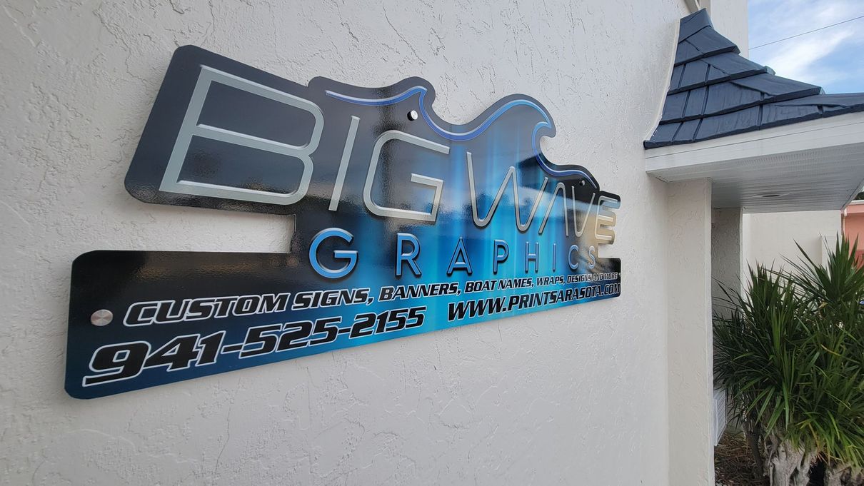 A sign on the side of a building that says big wave graphics