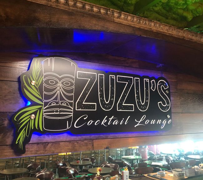 A restaurant with a sign that says ' zuzu 's cocktail lounge ' on it