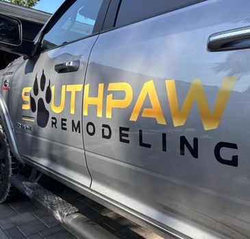 A silver truck with the word southpaw remodeling on the side