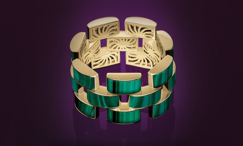 A gold and turquoise bracelet on a purple background