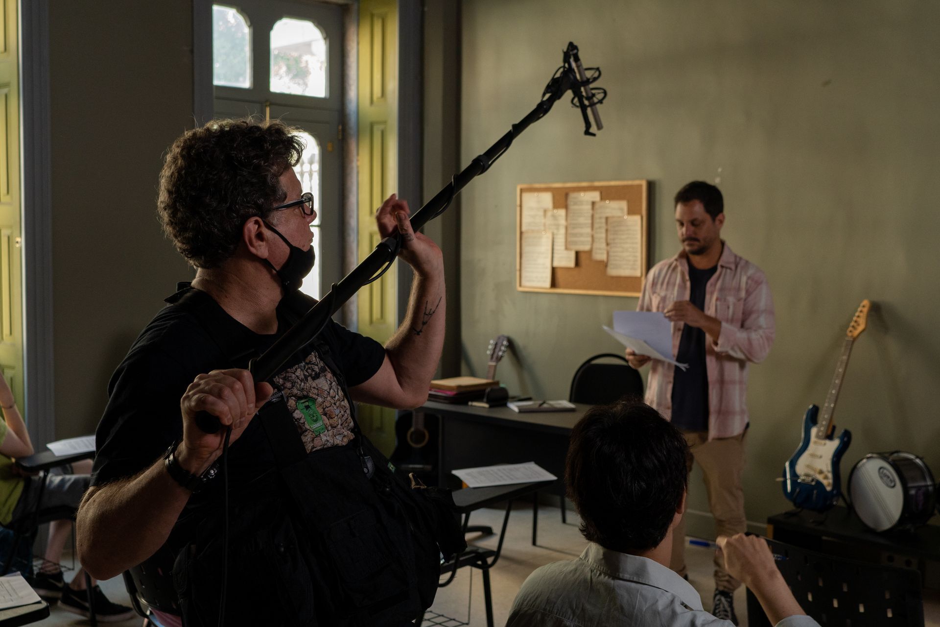 A man is holding a microphone in front of a group of people in a room.