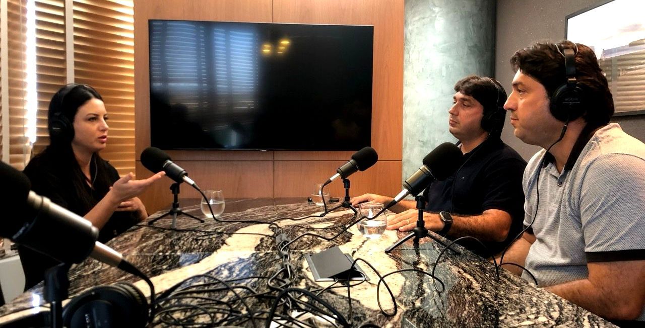 A group of people are sitting at a table in front of microphones.